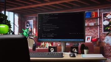 UI on computer monitor in home office with programming script being executed. Empty modern apartment room with coding application used by remote employee to write code, jib up shot video