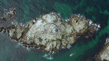 rocky island and lighthouse Top down drone view video