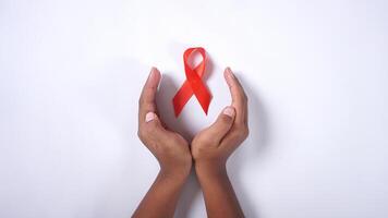 HIV AIDS Awareness Red Ribbon in Cupped Hands photo