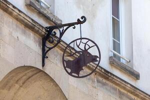 Old rusty wrought iron sign depicting a deer head photo