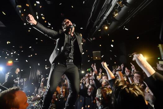 energético cantante ejecutando en etapa en medio de papel picado y aplausos multitud un emocionante concierto experiencia foto