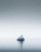 An iceberg floating in the ocean with a gray sky photo