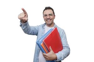 A man smiling and pointing while holding colorful folders in a bright environment. photo