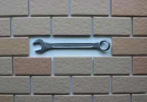 Steel Spanner In Compartment Inside Tiles Brickwork Top View. Stock Photo For DIY Repair Illustration