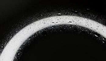 Small and large drops of water on a glass surface illuminated from below closeup view photo