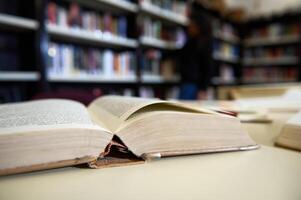 Open Book in Library With Shelves Blurred in Background photo