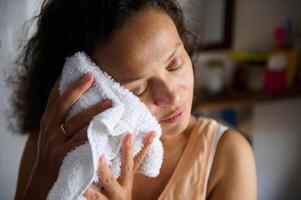 Woman Gently Caring For Her Skin Using a Soft Towel at Home photo