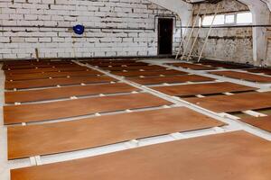A patchwork of warmth unfolds as multiple brown panels lay scattered on a rustic workshop floor, each surface telling a silent story of craftsmanship and creativity waiting to be unleashed photo