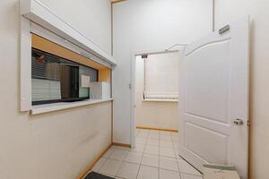 Quiet Transition A Glimpse Through the Service Window of a Tiled Room Inviting Discovery Beyond the Doorway. photo