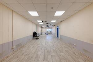 Echoes of Potential An Unoccupied Space Awaits Transformation with Its Tiled Floors and Stark Fluorescent Glow. photo