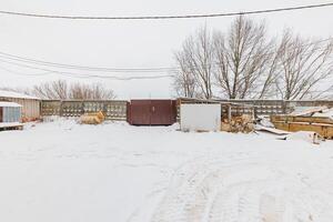 Winters Embrace A Frosted Gate Guarding a Serene Snowy Landscape, Framed by Whispering Trees. photo