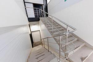 Ascending Light A Sleek Metal Staircase Navigating Through Minimalist Spaces Discover the Harmony of Modern Design in Indoor Architecture. photo