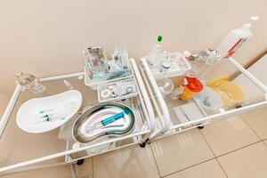 Clinical Precision A Close-Up of Essential Medical Gear - A meticulously organized tray showcases an array of syringes, bottles, and small containers, embodying the essence of modern healthcare. photo