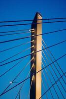Skyward Symphony A Majestic Dance of Steel and Cables - The towering structure stretches gracefully into a boundless blue, embodying the harmony between engineering and natures canvas. photo