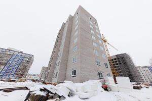 Silent Construction A Towering Structure Amidst Winters Embrace, Where Dreams of Home Await Completion. photo