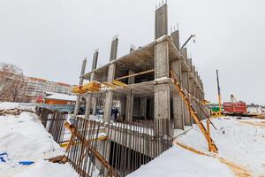 Amidst the Winter Chill A Towering Structure Takes Shape, Enveloped in Snowy Serenity and Surrounded by Scaffolding. photo