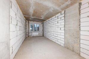 Echoes of Potential A Raw Space Bathed in Natural Light from a Single Window, Awaiting Transformation photo