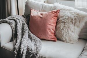 A beautiful white couch adorned with pillows and a cozy blanket on it photo