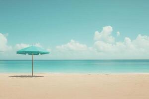 Beach umbrella in turquoise color standing on sand under clear sky photo