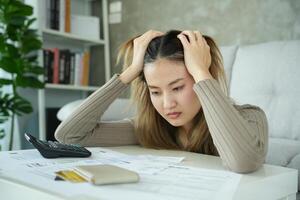 asian woman with large bills or invoices no money to pay to expenses and credit card debt. shortage, Financial problems, mortgage, loan, bankruptcy, bankrupt, poor, empty wallet photo