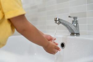 kid hands wash with soap bubbles and rinse with clean water to prevent and stop the spread of germs after back to home, virus or covid19. Good health and good personal hygiene, virus, bacteria photo