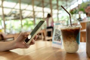 Woman use smartphone to scan QR code to pay in cafe restaurant with a digital payment without cash. Choose menu and order accumulate discount. E wallet, technology, pay online photo