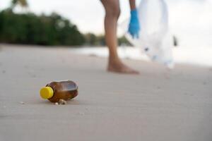 Volunteer pick up trash garbage at the beach and plastic bottles are difficult decompose prevent harm aquatic life. Earth, Environment, Greening planet, reduce global warming, Save world. photo