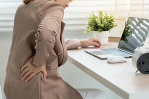 lower back while and suffer from unbearable pain health and problems, chronic back pain, backache in office syndrome, scoliosis, herniated disc photo