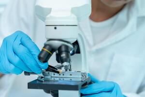 Scientist analyze biochemical samples in advanced scientific laboratory. Medical professional use microscope look microbiological developmental of viral. Biotechnology research in science lab photo
