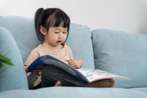 Happy Asian children relax read book at home. daughter and reading a story. learn development, childcare, laughing, education, storytelling, practice, imagine photo