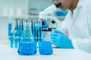 Scientist analyze biochemical samples in advanced scientific laboratory. Medical professional use microscope look microbiological developmental of viral. photo