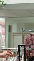 Vertical Fashion store employee assisting a male client with style choices, emphasizing customer service and presenting the new collection of quality garments. Personalized shopping experience. Camera A. video