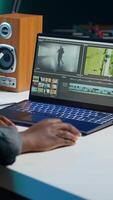 Vertical editor selecting key frames to use while doing montage, working from home on notebook device. Woman using mouse to edit movie project footage in apartment office, camera A video