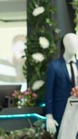 Vertical Designer boutique assistant arranging a vibrant selection of garments on racks, highlighting stylish new collection apparel and creating a welcoming shopping experience for customers. Camera A. video