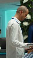 vertical masculino Al por menor asistente organizando calidad ropa en monitor en un almacenar, mejorando el compras experiencia para clientes y el genial vibras. asegurando un bueno consumidor comportamiento. cámara una. video