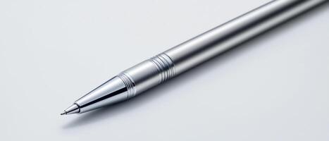 sleek silver pen resting on smooth surface, ideal for writing photo