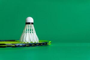 Badminton rackets and shuttlecocks arranged on a green background photo
