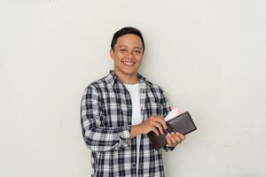 Young Asian man take out his money from the wallet with happy expression. Man smiling while holding his wallet photo