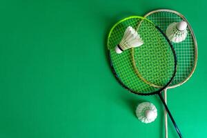 Top angle view of badminton rackets and shuttlecocks over green background. photo