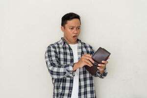 Asian man shocked and thinking looking to his empty wallet. Financial problem concept. photo