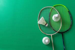 Flat lay of badminton rackets and shuttlecocks on a vibrant green background photo