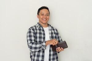 Handsome Asian man take out his money from the wallet with happy expression. Man smiling while holding his wallet photo