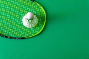 racket and shuttlecock on green background photo