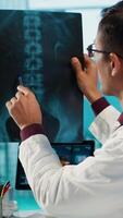 Vertical Indian healthcare expert sharing medical expertise with a patient in office, reviewing x ray scans and MRI diagnostics to focus on accurate treatment and recovery. Insurance consultation. Camera A. video
