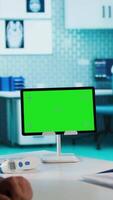 Vertical Indian physician consulting male patient in medical facility next to chroma key, using technology for scan interpretation and diagnostics. Medic giving professional advice based on records. Camera A. video