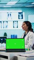 Vertical Indian medic consulting her patient in medical facility next to copy space, using advanced technology for scan interpretation and diagnostics. Expert gives advice based on records. Camera B. video