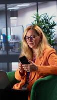 Vertical Female leader contacting partners via smartphone conference call, discussing about latest developments and investments. Woman business manager speaking on remote phone call, decision maker. Camera A. video
