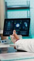 Vertical Physician meeting with patient to discuss medical test results in cabinet, using advanced diagnostic tools to interpret x ray scans, demonstrating a professional healthcare approach. Camera A. video