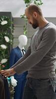 Vertical Modern stylish store employee helping a client explore clothing options, symbolizing a commitment to style and customer satisfaction. Diverse men discussing fashion expertise. Camera B. video