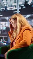 Vertical General manager in a briefing meeting feeling sick and anxious, strategizing for corporate success with a headache. Empowered woman leader being overwhelmed and tired under pressure. Camera B. video
